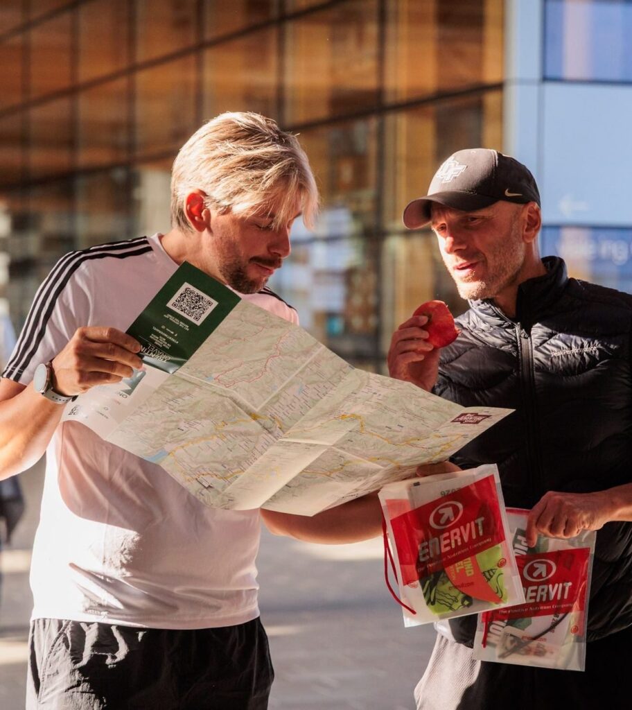 Two riders study the printed route map at event pack pickup